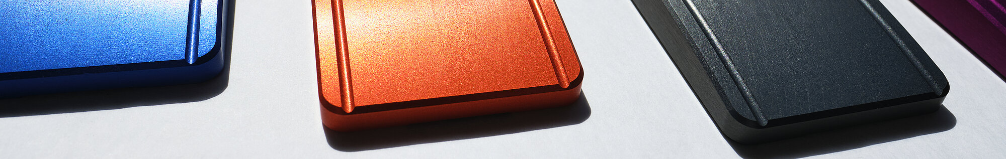 Eloxierte Aluminiumbauteile in Blau, Orange, Schwarz und Violett